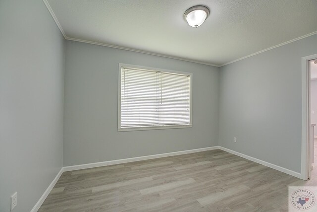 spare room with light wood-type flooring and ornamental molding