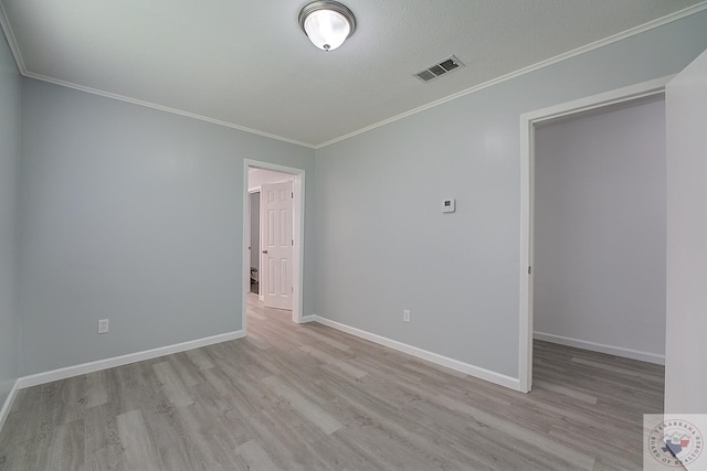 spare room featuring light hardwood / wood-style flooring and ornamental molding