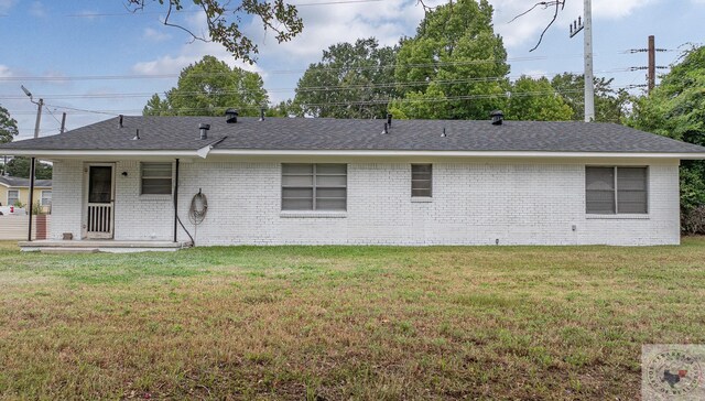 back of house with a patio area and a lawn