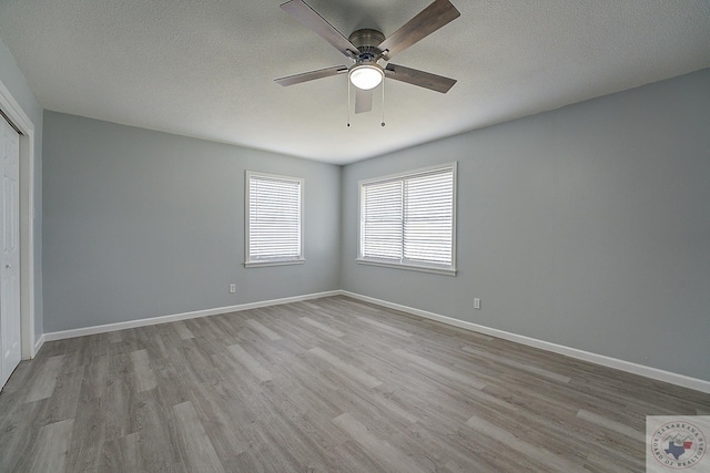 unfurnished room with light hardwood / wood-style floors, a textured ceiling, and ceiling fan