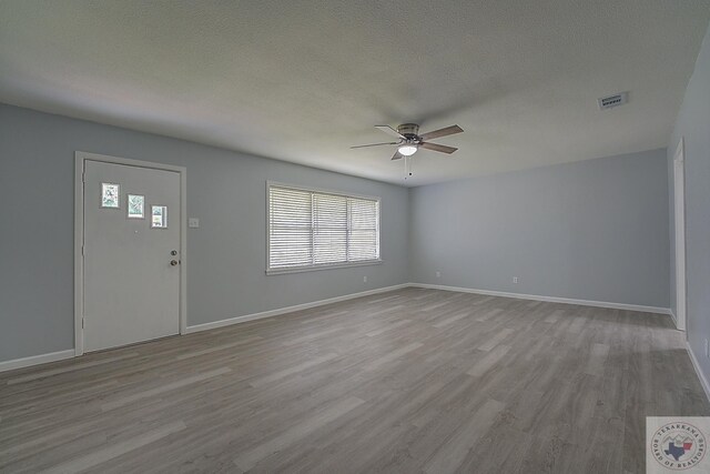 foyer entrance featuring light hardwood / wood-style floors, a textured ceiling, and ceiling fan