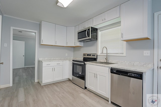 kitchen with crown molding, light hardwood / wood-style floors, appliances with stainless steel finishes, white cabinets, and sink