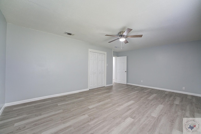 spare room with ceiling fan, light hardwood / wood-style floors, and a textured ceiling