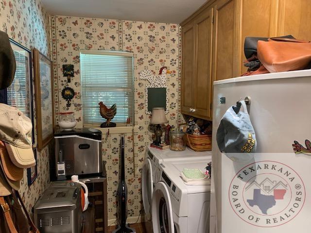 clothes washing area featuring cabinets and independent washer and dryer