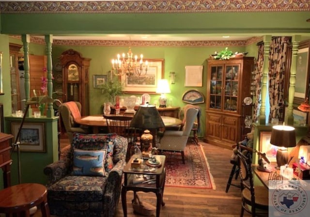 dining room featuring decorative columns, wood-type flooring, and a notable chandelier