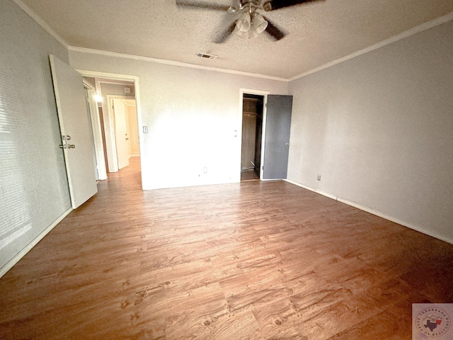 unfurnished bedroom with crown molding, wood-type flooring, a textured ceiling, and ceiling fan