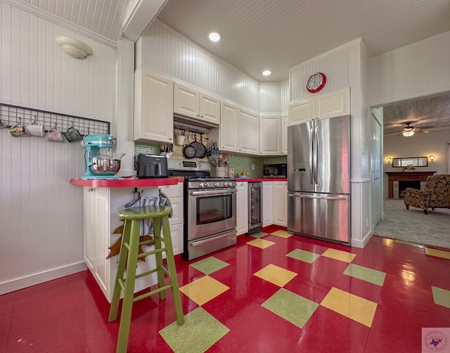 kitchen featuring white cabinetry, beverage cooler, dark floors, and appliances with stainless steel finishes