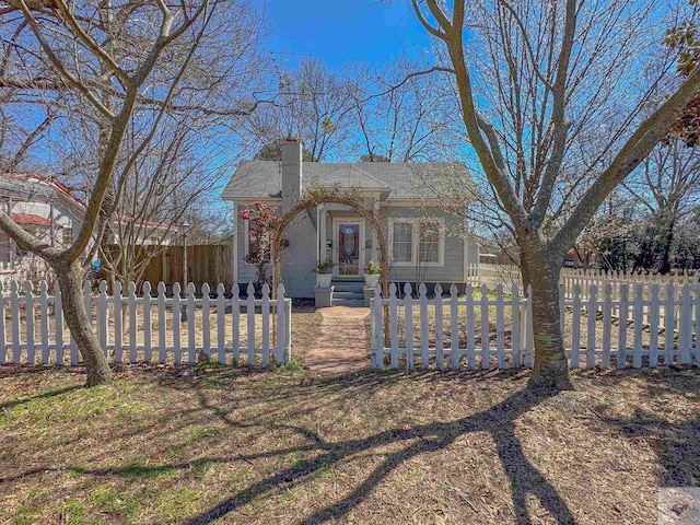 view of front of property featuring a fenced front yard and a chimney