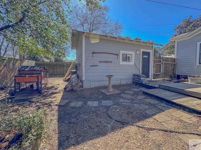 back of house with a wooden deck, an outbuilding, and a fenced backyard