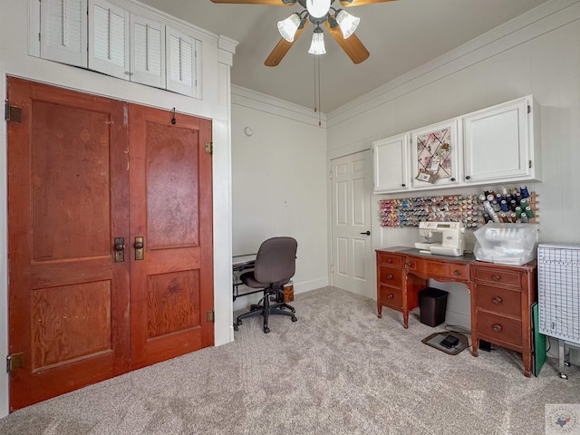 carpeted office space with a ceiling fan and crown molding