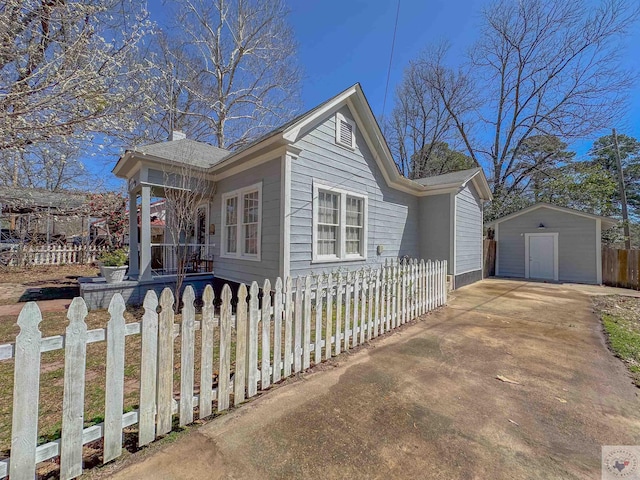 view of home's exterior with an outdoor structure, a storage unit, and a fenced front yard