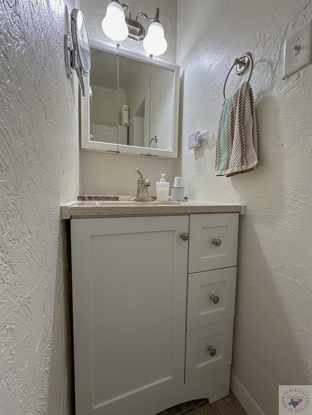 bathroom with vanity and a textured wall