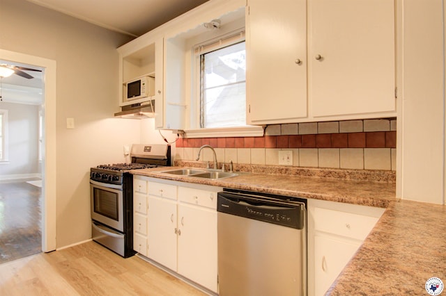 1920 Laurel St, Texarkana, AR 71854 - kitchen with stainless steel appliances, a sink, light wood-style floors, white cabinetry, and light countertops