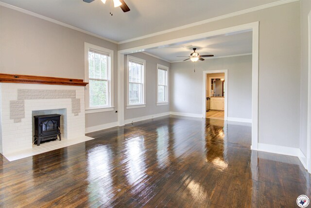 1920 Laurel St, Texarkana, AR 71854 - unfurnished living room with a ceiling fan, a wood stove, baseboards, hardwood / wood-style flooring, and crown molding