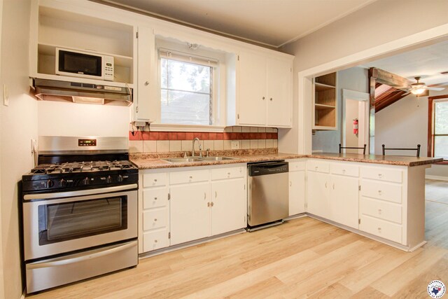 1920 Laurel St, Texarkana, AR 71854 - kitchen featuring appliances with stainless steel finishes, a sink, under cabinet range hood, light wood-style floors, and white cabinetry