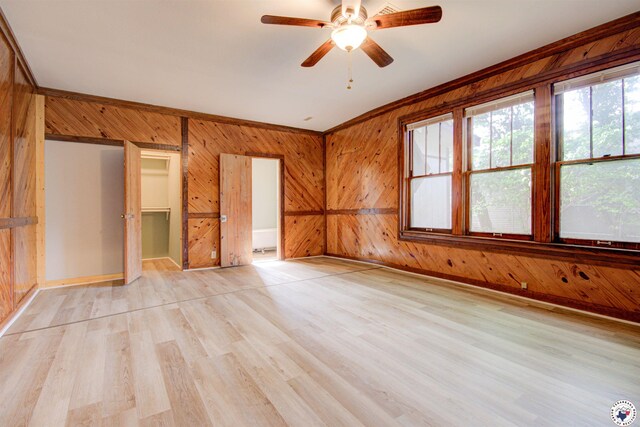 1920 Laurel St, Texarkana, AR 71854 - unfurnished bedroom featuring wood walls, light wood-style flooring, baseboards, crown molding, and ceiling fan