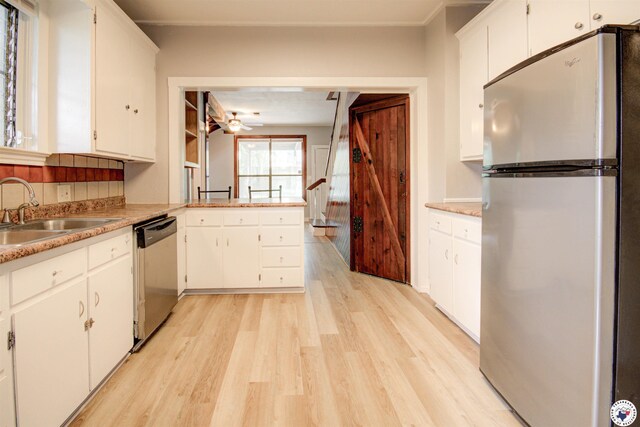 1920 Laurel St, Texarkana, AR 71854 - kitchen with stainless steel appliances, a sink, light wood-style flooring, and white cabinets