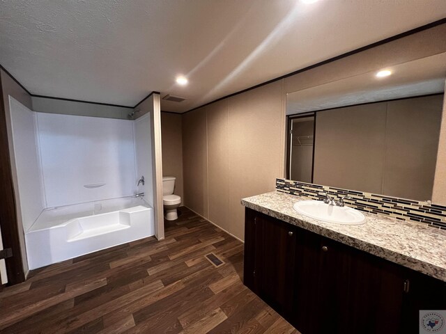 2 Rayn St, Texarkana, TX 75501 - full bath with tasteful backsplash, visible vents, toilet, vanity, and wood finished floors
