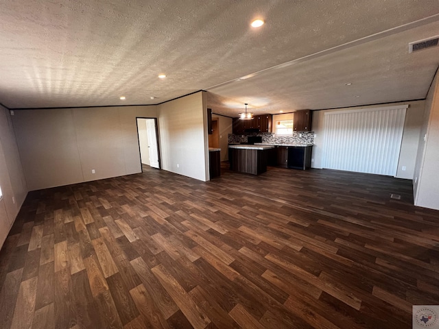 2 Rayn St, Texarkana, TX 75501 - unfurnished living room featuring a textured ceiling, dark wood finished floors, visible vents, and recessed lighting