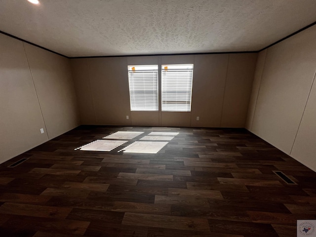 2 Rayn St, Texarkana, TX 75501 - unfurnished room with a textured ceiling, dark wood-type flooring, and visible vents