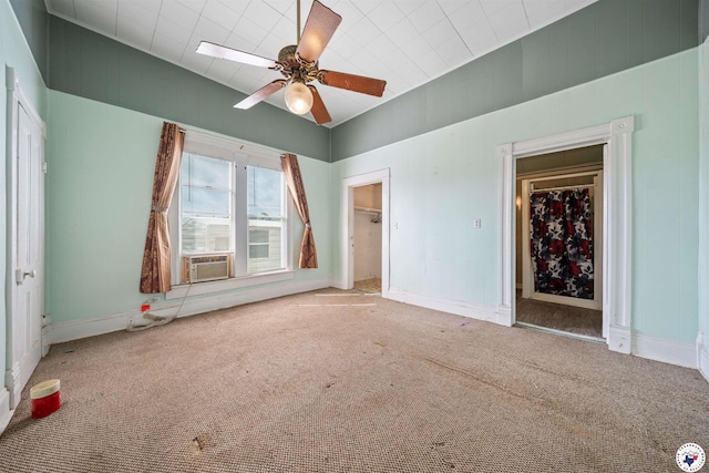 unfurnished bedroom with cooling unit, baseboards, carpet floors, and a spacious closet