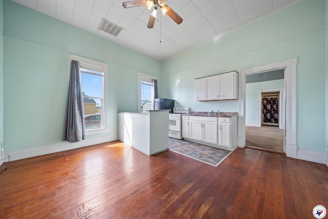kitchen featuring white cabinets, visible vents, a ceiling fan, a sink, and gas range gas stove
