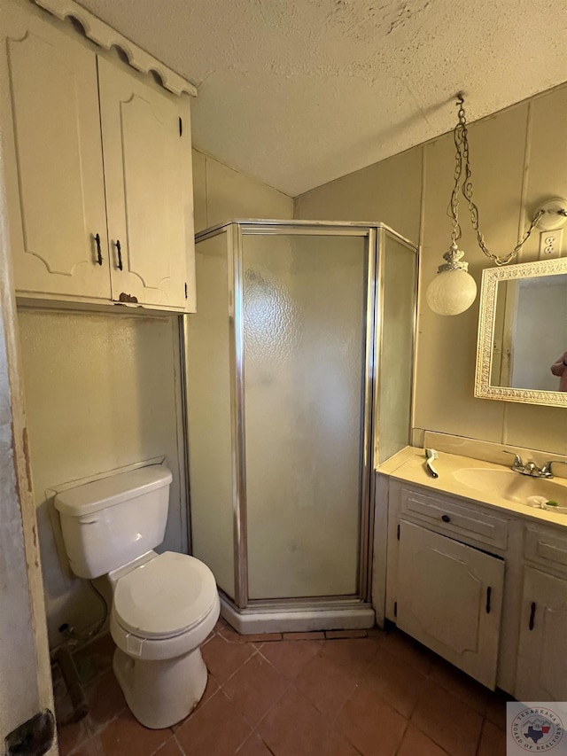 bathroom with tile patterned flooring, toilet, a textured ceiling, walk in shower, and vanity