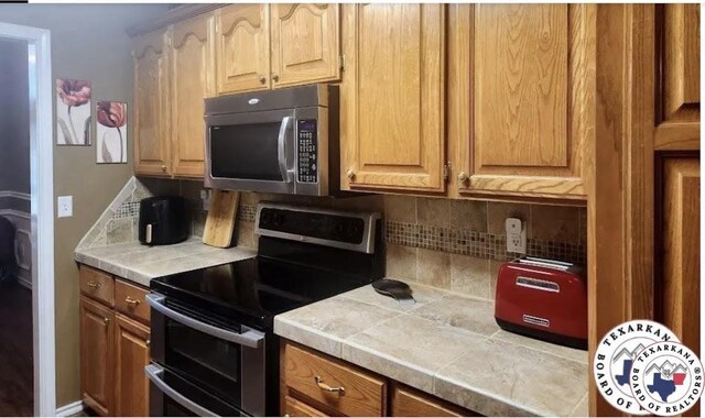 147 Mc 458, Texarkana, AR 71854 - kitchen with stainless steel appliances, backsplash, and tile countertops
