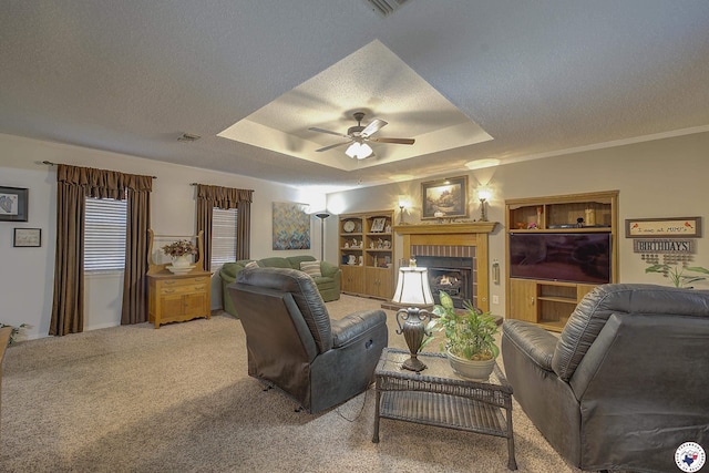 3916 Sabine Ave, Texarkana, TX 75503 - living room featuring a textured ceiling, a ceiling fan, a fireplace, light carpet, and a raised ceiling