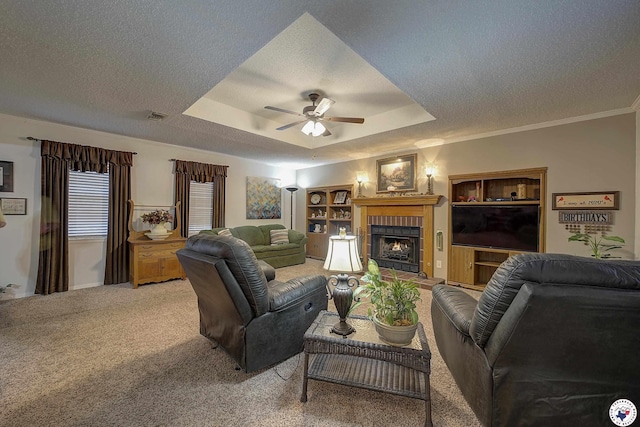 3916 Sabine Ave, Texarkana, TX 75503 - living area with a textured ceiling, a raised ceiling, ceiling fan, a fireplace, and light colored carpet