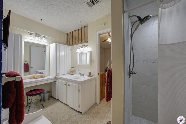 3916 Sabine Ave, Texarkana, TX 75503 - full bathroom featuring tiled shower, ceiling fan, a textured ceiling, and vanity