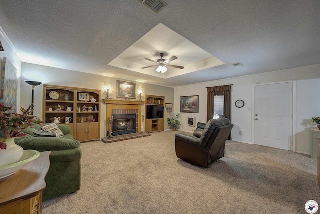 3916 Sabine Ave, Texarkana, TX 75503 - living room featuring a textured ceiling, ceiling fan, a tray ceiling, a fireplace, and carpet floors