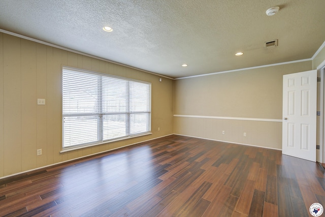 spare room featuring a textured ceiling, a wealth of natural light, visible vents, and wood finished floors