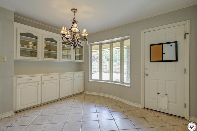 unfurnished dining area featuring light tile patterned floors, a notable chandelier, crown molding, and baseboards