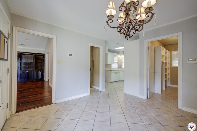 unfurnished dining area featuring ornamental molding, light tile patterned flooring, visible vents, an inviting chandelier, and baseboards