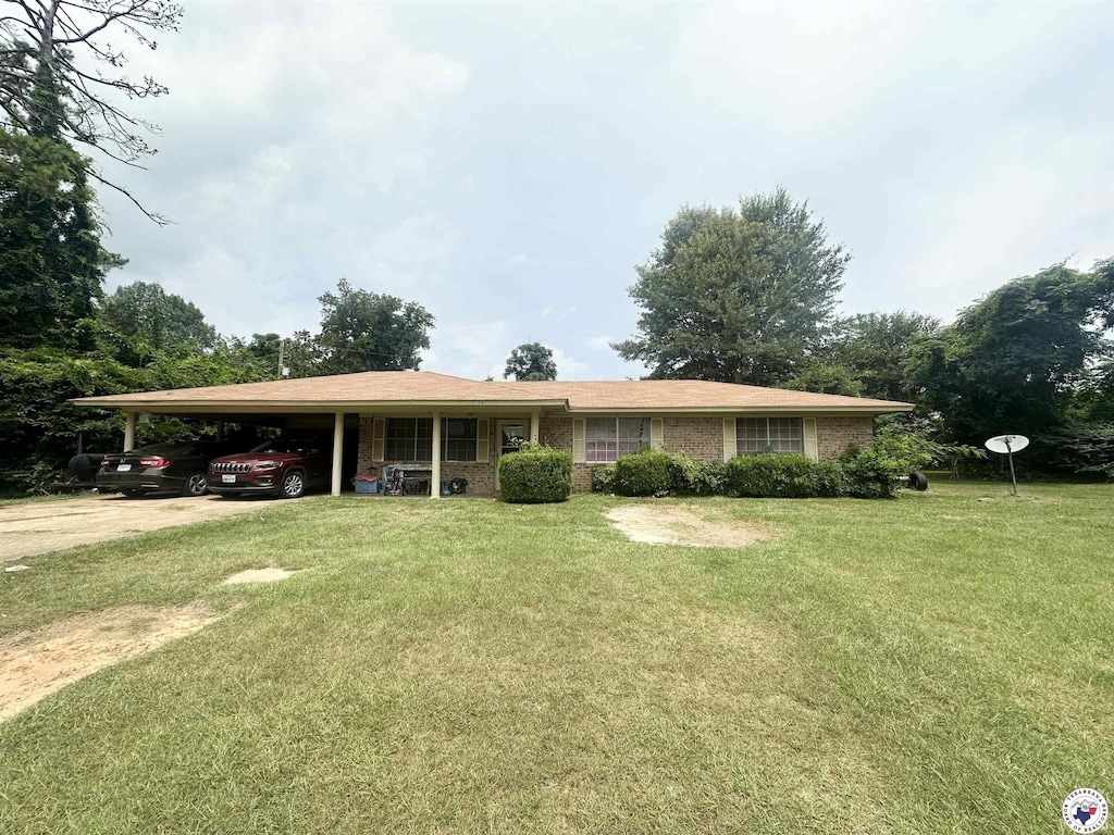 709 Mimosa Ln, Atlanta, TX 75551 - ranch-style home with a front yard, an attached carport, and brick siding