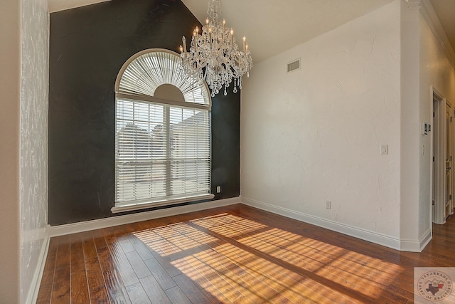 spare room featuring vaulted ceiling, a chandelier, and hardwood / wood-style flooring