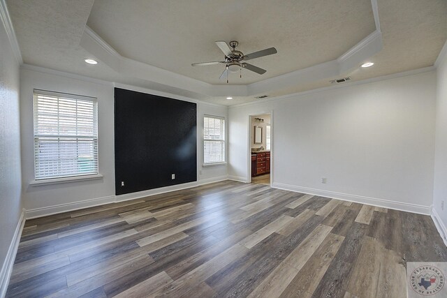 unfurnished room featuring ceiling fan, ornamental molding, a tray ceiling, and dark hardwood / wood-style flooring