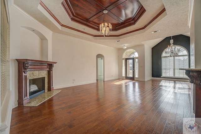 unfurnished living room with a chandelier, a high end fireplace, ornamental molding, and wood-type flooring