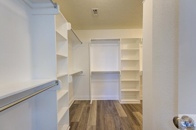 spacious closet with dark wood-type flooring