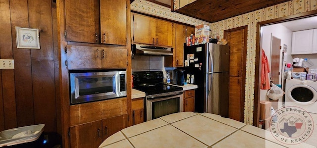 kitchen featuring washer / dryer, tile countertops, and stainless steel appliances