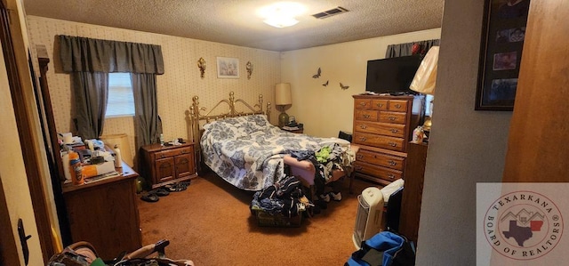 bedroom with carpet floors and a textured ceiling