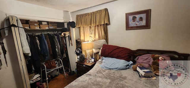 bedroom with dark wood-type flooring, a closet, and a textured ceiling