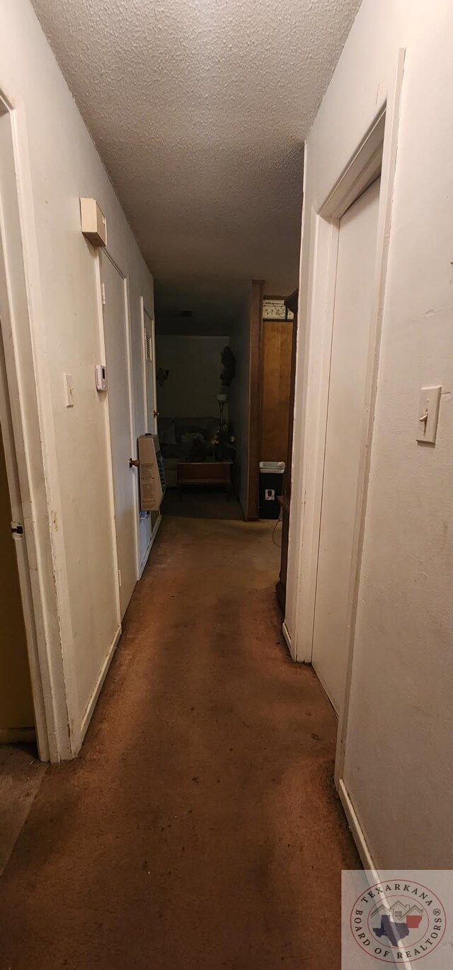 hallway with a textured ceiling