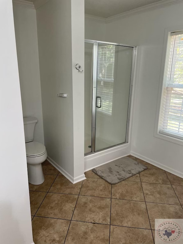 bathroom featuring toilet, ornamental molding, an enclosed shower, and tile patterned flooring