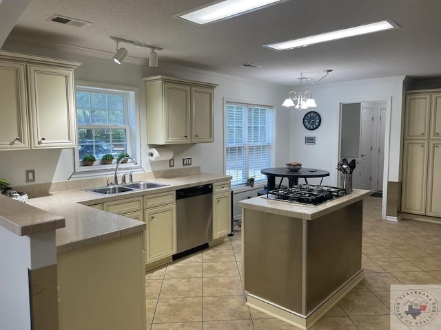 kitchen featuring sink, a textured ceiling, appliances with stainless steel finishes, and cream cabinets