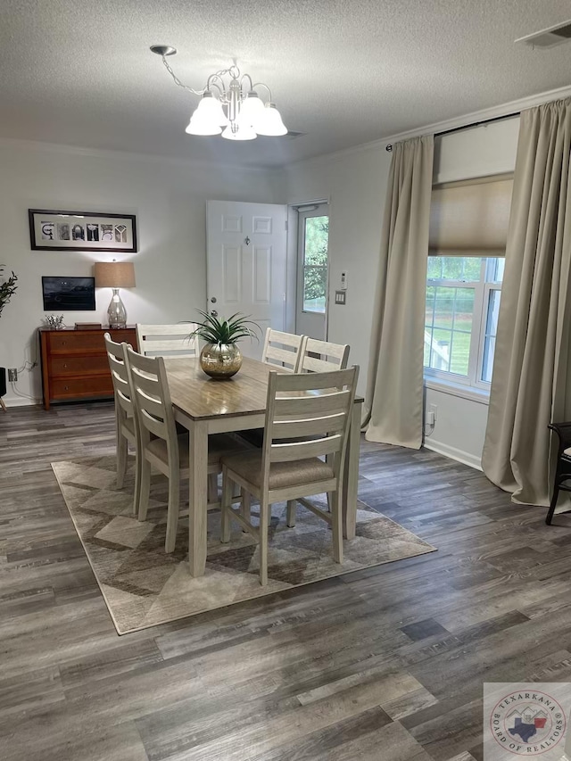 dining space featuring plenty of natural light, a textured ceiling, and a chandelier