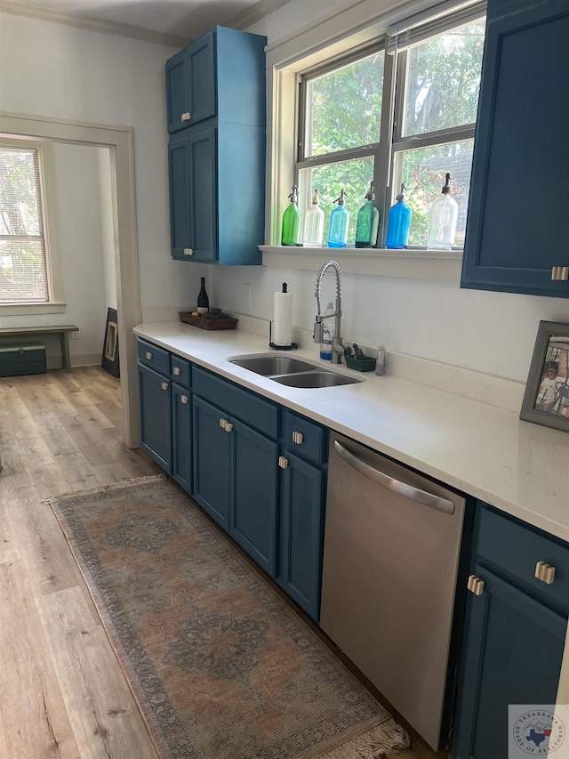 kitchen featuring a wealth of natural light, blue cabinetry, light hardwood / wood-style floors, stainless steel dishwasher, and sink