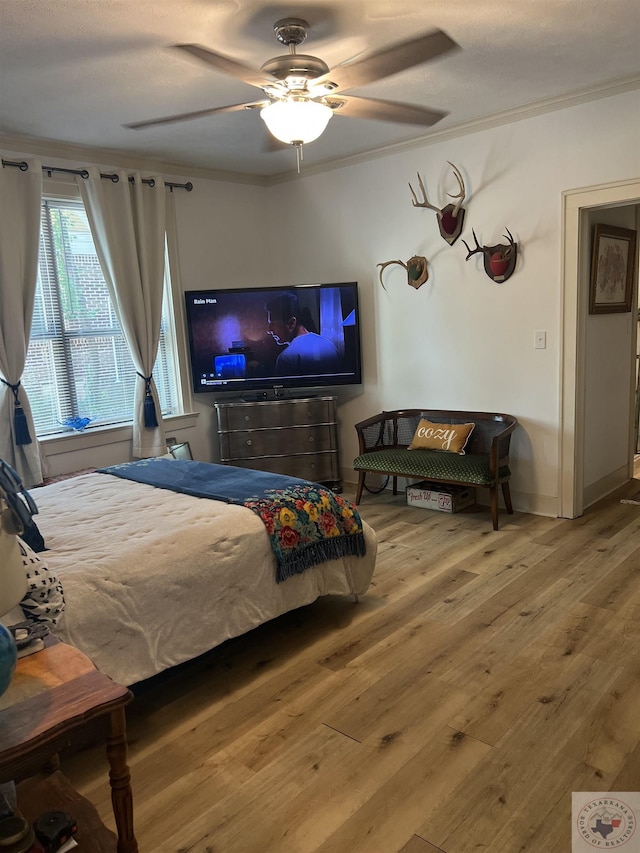 bedroom featuring ceiling fan, crown molding, and hardwood / wood-style flooring