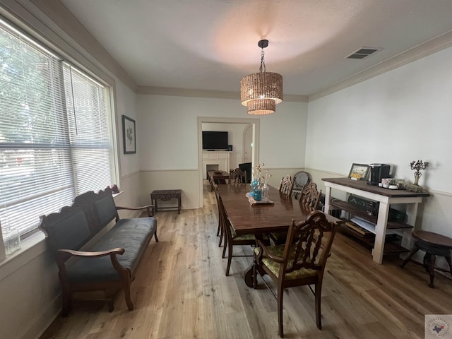 dining room with ornamental molding, a wealth of natural light, and hardwood / wood-style floors